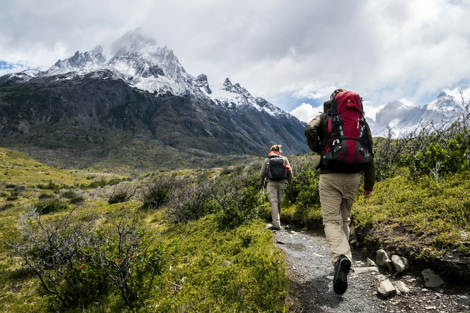 Two people hiking together through a mountain valley